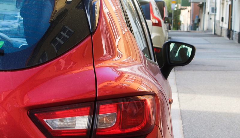 Baksiden av en rød bil som står parkert