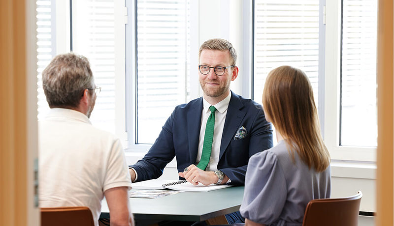 En mann i dress har møte med to klienter