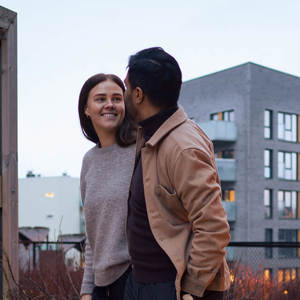 Bilde av et ungt par som går ute - de ser på hverandre og smiler