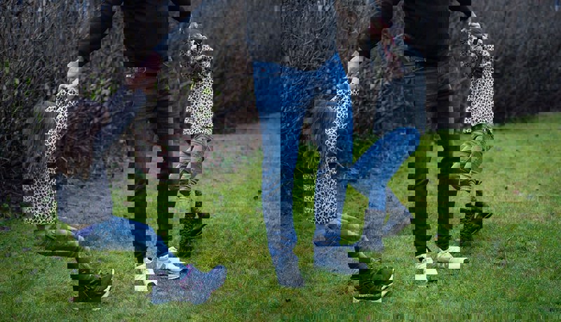 En far med to døtre leker i hagen