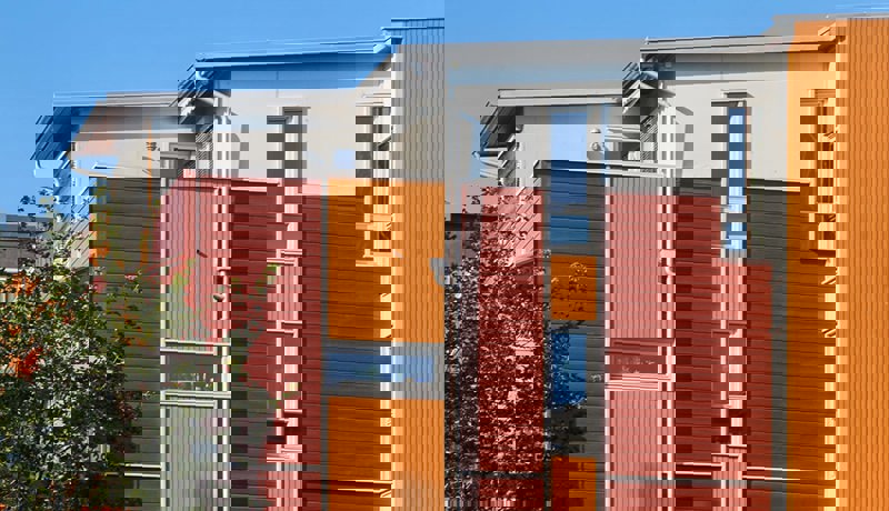 Et boligbygg med sterke farger i rødt og oransj