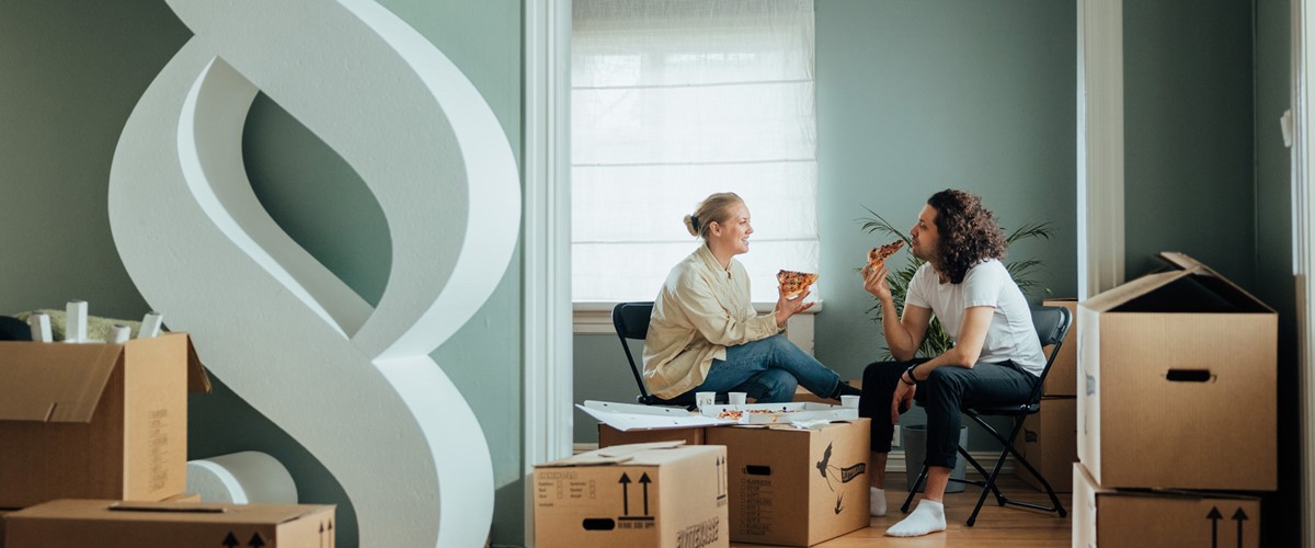 To boligkjøpere spiser pizza under innflytting