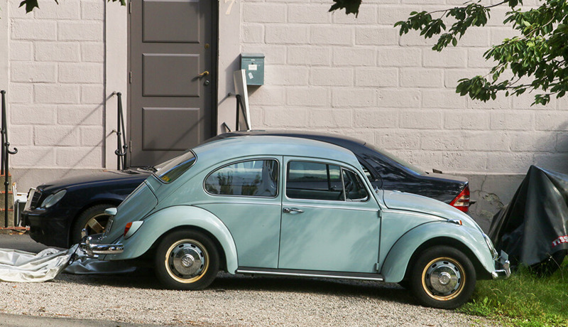 En eldre VW Golf står parkert foran en bygning