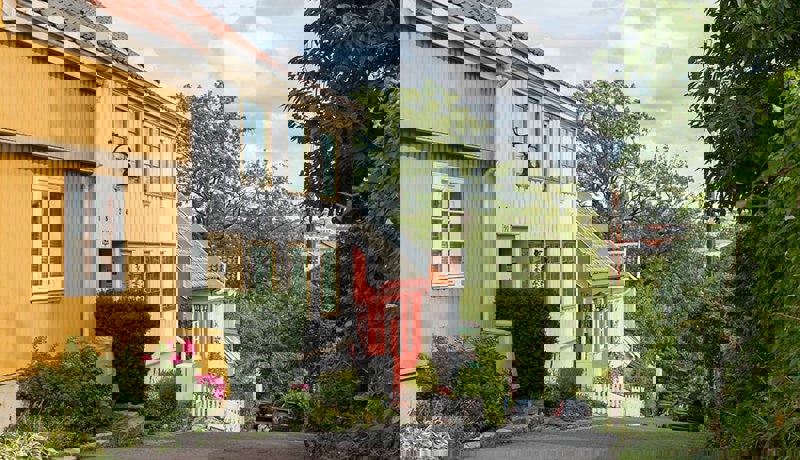 Eldre hus står på rekke og rad i en nedoverbakke