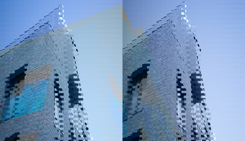 Moderne boligbygg med store vinduer og franske balkonger