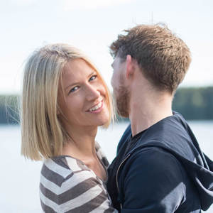 Et ungt par holder rundt hverandre og ser lykkelige ut