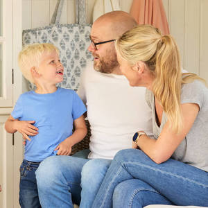 Bilde av mor og far som ser mot sønnen sin og han ser på dem og smiler