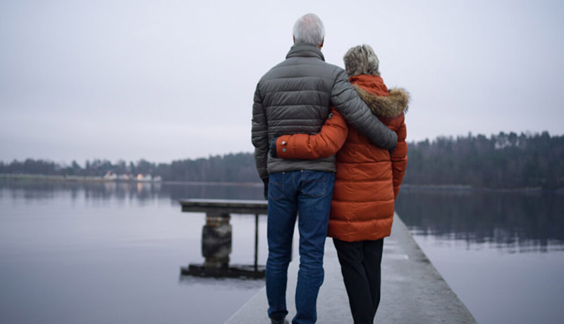 Et eldre par ser ut mot et vann og holder rundt hverandre