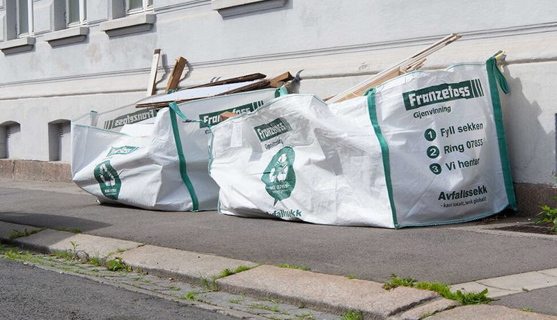 Avfallssekker står utenfor et boligbygg - klare til henting