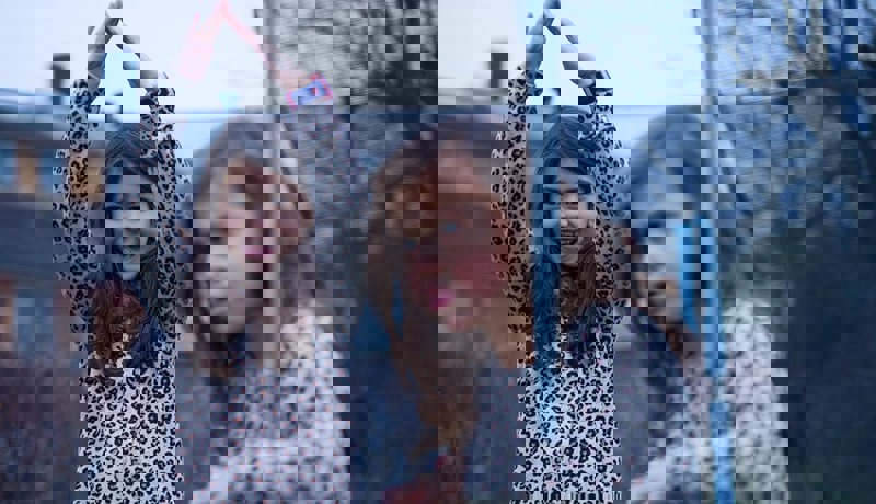 To søstre leker i hagen ved trompolinen