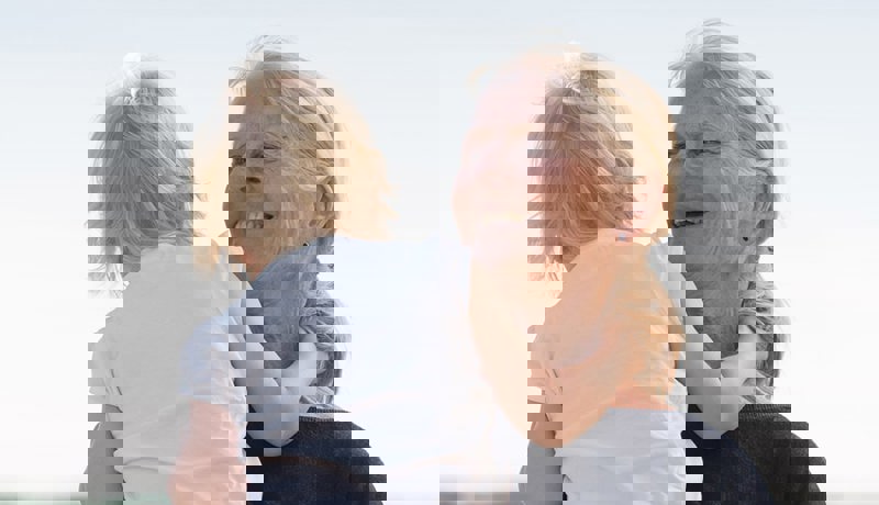 Bestemor holder et lite barn og ser lykkelig ut