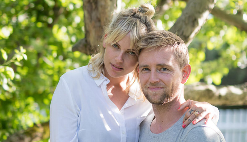 Et ungt par holder rundt hverandre og ser lykkelige ut