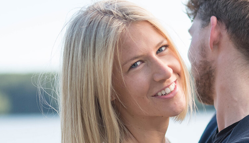 Et ungt par holder rundt hverandre og ser lykkelige ut