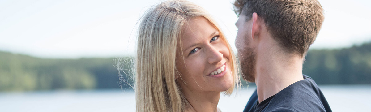 Et ungt par holder rundt hverandre og ser lykkelige ut