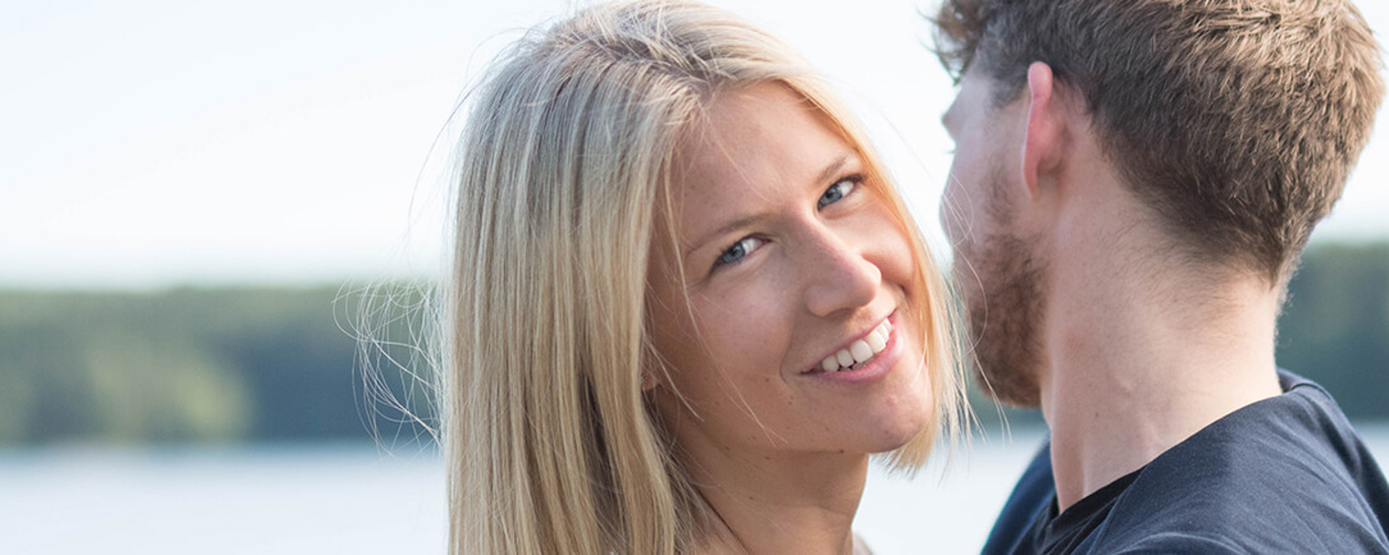 Et ungt par holder rundt hverandre og ser lykkelige ut