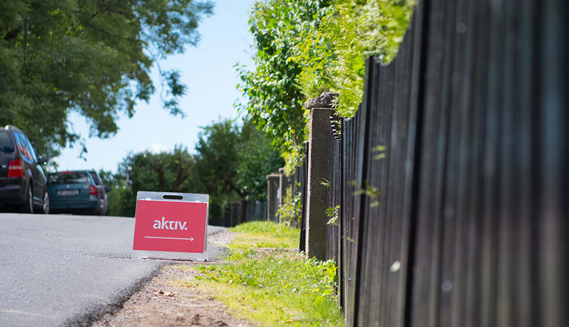 Et skilt ved siden av et gjerde peker rett inn til visning av en bolig