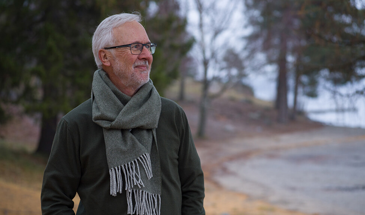 En eldre mann står ute og ser tankefull ut