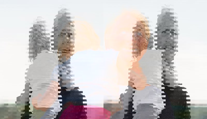 Bestemor holder et lite barn og ser lykkelig ut