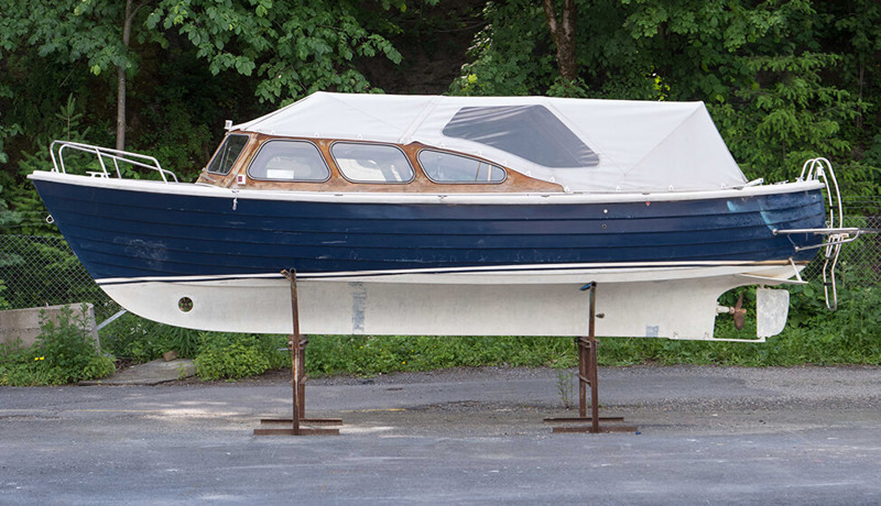 En eldre båt står på lagringsstylter på land