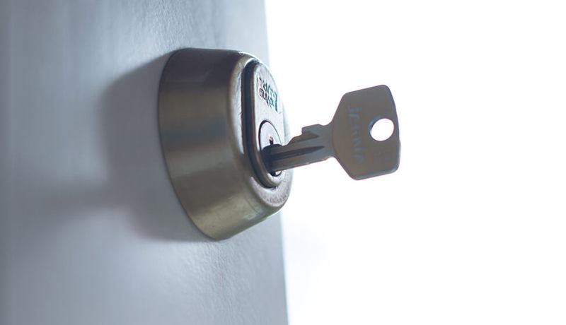 En nøkkel står plassert i låsen på en dør