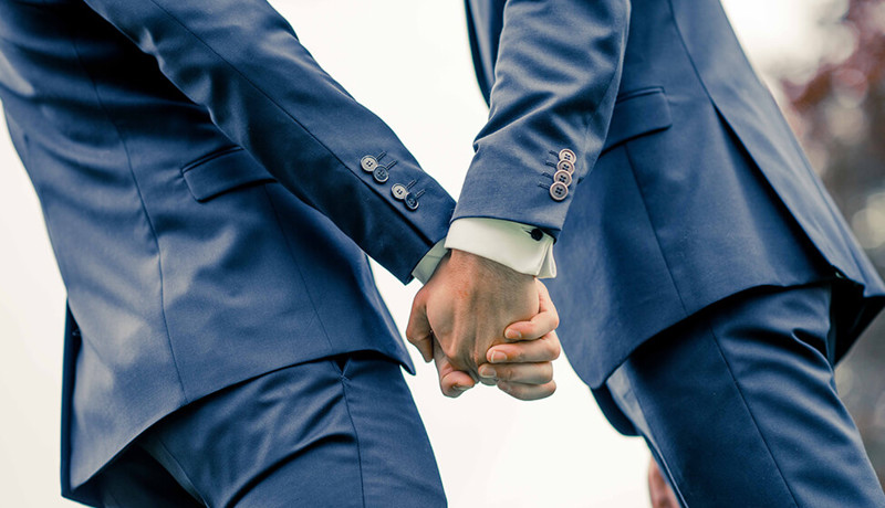 To menn i dress holder hender