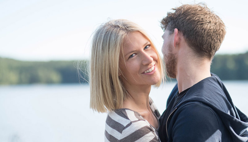 Et ungt par ser glade ut mens de holder rundt hverandre